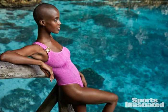 Madisin Rian leans against a wooden railing above a natural pool.